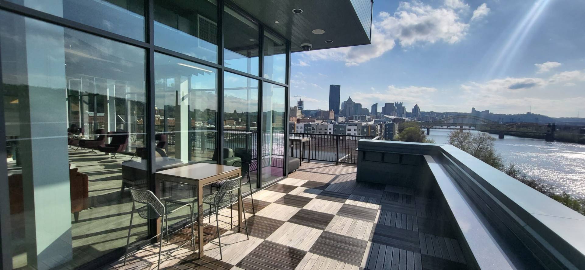 Club room deck with seating, tables, and a view of downtown Pittsburgh
